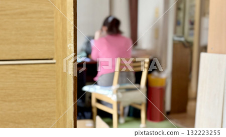 隔壁房間一位女士坐在桌邊的背影 132223255