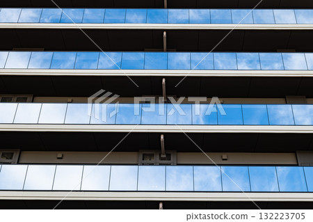 A modern apartment building with beautiful reflective glass and clean lines A modern apartment building with beautiful reflective glass and clean lines 132223705