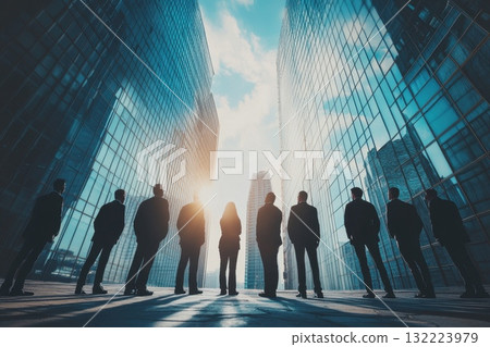 Business People Silhouetted Against Modern Skyscrapers and Blue Sky in Urban Setting Business People Silhouetted Against Modern Skyscrapers and Blue Sky in Urban Setting 132223979