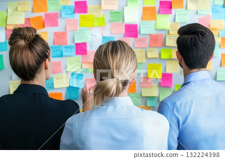 Team Members Collaborating in a Modern Office Environment with Sticky Notes on Wall 132224398