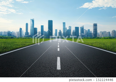 Expansive Road Leading to Modern City Skyline Under Bright Blue Sky and Green Grass 132224446