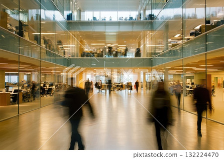 Busy Modern Office Building with Glass Interior and Professionals Moving in Motion Busy Modern Office Building with Glass Interior and Professionals Moving in Motion 132224470