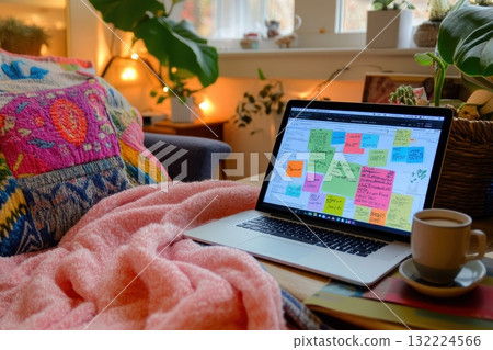 Cozy Home Office Setup with Laptop, Colorful Blankets, and Creative Sticky Notes 132224566