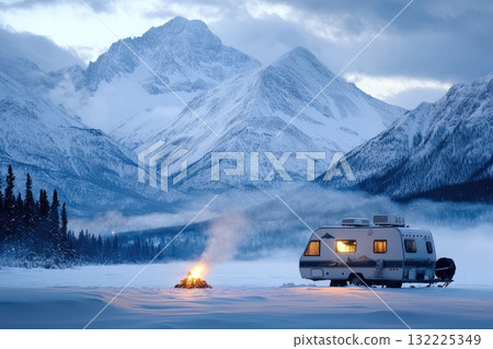 Serene Winter Camping Scene with a Camper and Campfire in a Snowy Landscape Surrounded by Majestic Mountains Under a Dramatic Sky at Dusk 132225349