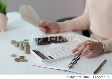 Financial Planning. Woman calculating expenses with a calculator and cash. Financial Planning. Woman calculating expenses with a calculator and cash. 132225494