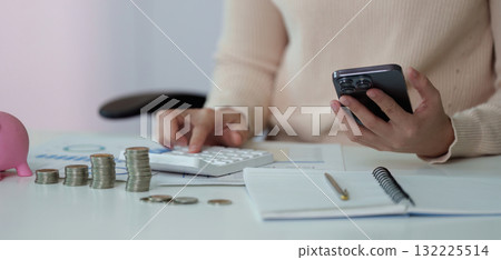 Financial Management. Calculating expenses with a smartphone and calculator. 132225514