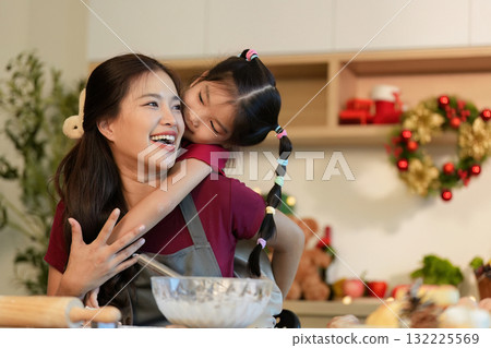Holiday Baking. Joyful mother and daughter making festive treats together in a cozy kitchen. 132225569