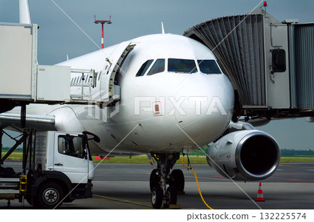 Charter airline airplane preparing for flight on airport runway with connected jet boarding bridge Charter airline airplane preparing for flight on airport runway with connected jet boarding bridge 132225574