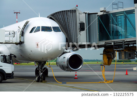 Charter airline airplane preparing for flight on airport runway with connected jet boarding bridge Charter airline airplane preparing for flight on airport runway with connected jet boarding bridge 132225575