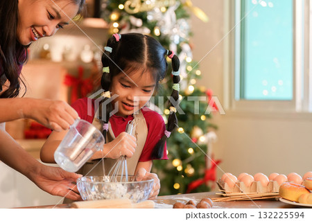 Whisking Together A mother and daughter preparing holiday treats in a festive kitchen Whisking Together A mother and daughter preparing holiday treats in a festive kitchen 132225594