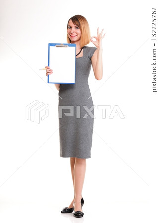 Full length young business woman standing with her clipboard isolated 132225762