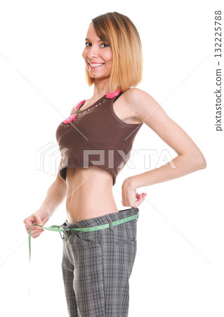 Pretty woman shows her weight loss wearing measure tapes isolated Pretty woman shows her weight loss wearing measure tapes isolated 132225788