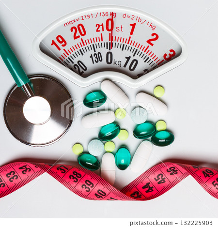 Pills stethoscope measuring tape on scales. Health care Pills stethoscope measuring tape on scales. Health care 132225903
