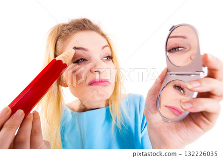 Woman painting eyebrows using regular pencil 132226035