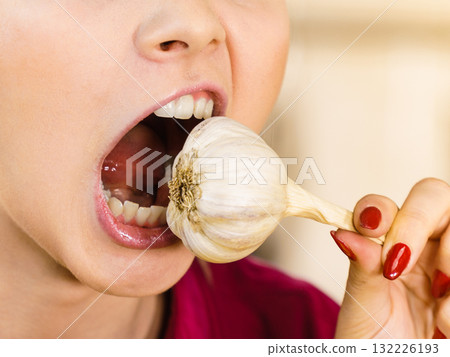 Crazy girl eating garlic vegetable Crazy girl eating garlic vegetable 132226193