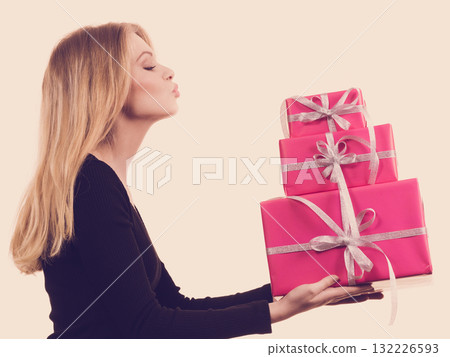 Girl holding stack of pink gift boxes Girl holding stack of pink gift boxes 132226593