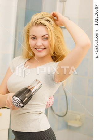 Woman drying sweat stains using hair dryer Woman drying sweat stains using hair dryer 132226687
