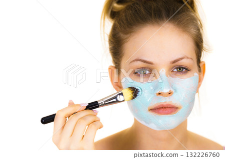 Girl apply green mud mask to face Girl apply green mud mask to face 132226760