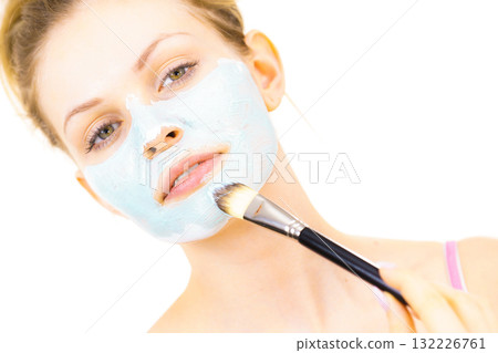 Girl apply green mud mask to face Girl apply green mud mask to face 132226761