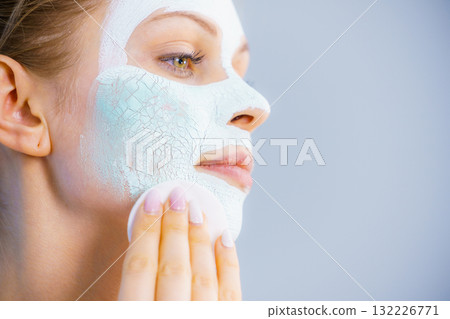 Girl removes dry white mud mask 132226771