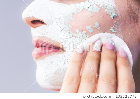 Girl removes dry white mud mask Girl removes dry white mud mask 132226772