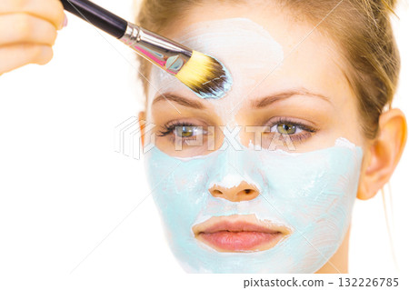 Girl apply green mud mask to face 132226785