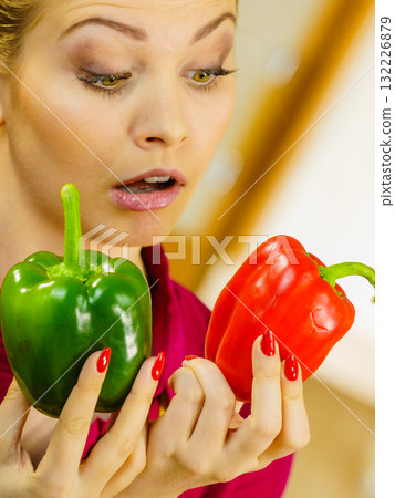 Woman holding bell peppers paprika thinking Woman holding bell peppers paprika thinking 132226879