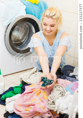 Woman wash laundry using detergent pods Woman wash laundry using detergent pods 132227377