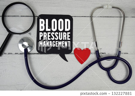 Blood Pressure Management text with Red heart, Magnifying glass and Medical Stethoscope on wooden background 132227881