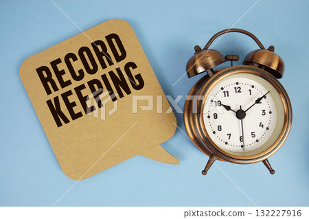 Record Keeping text with alarm clock on blue background 132227916