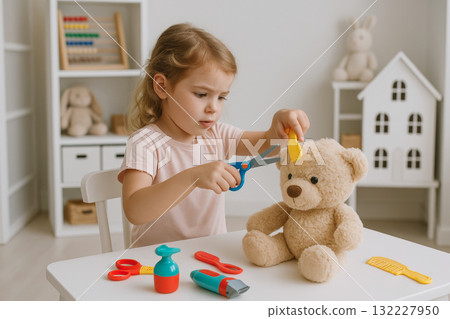 Young girl giving a teddy bear a playful haircut using toy scissors and comb in a cozy children's playroom. concept of imaginative play, childhood fun, creative expression. 132227950