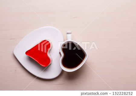 Heart shaped coffee cup and cake on wood surface Heart shaped coffee cup and cake on wood surface 132228252