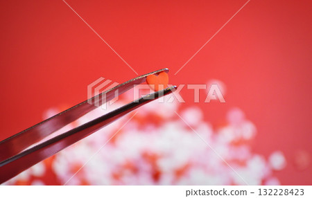 Heart-shaped topping sugar picked with tweezers. Stylish and cute background decoration. Feelings. Confectionery ingredients. Heart-shaped topping sugar picked with tweezers. Stylish and cute background decoration. Feelings. Confectionery ingredients. 132228423