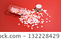 Heart-shaped sugar topping spilling from a small bottle. Cute background decoration. Overflowing feelings. Confectionery ingredients. 132228429