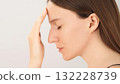 Side view of a young woman with closed eyes, showing signs of stress and discomfort. Concept of headache, fatigue, mental pressure or emotional tension. Copy space 132228739