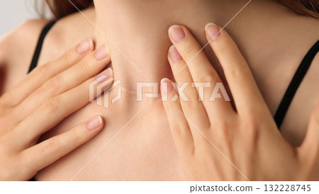 Close-up of an unrecognizable woman touching her neck. Endocrine health prevention, treatment. Diseases of the thyroid gland. Cancer screening. Endocrinology. Medical concept, Healthcare, Self-care. Close-up of an unrecognizable woman touching her neck. Endocrine health prevention, treatment. Diseases of the thyroid gland. Cancer screening. Endocrinology. Medical concept, Healthcare, Self-care. 132228745