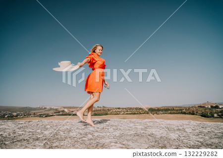 Woman in Orange Dress Enjoying the Sunny Day 132229282