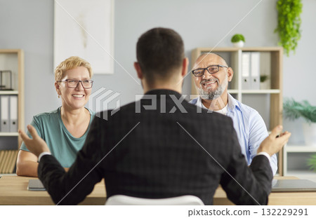 Senior couple meets friendly financial advisor to review documents in office Senior couple meets friendly financial advisor to review documents in office 132229291