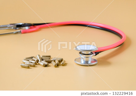 Duo stethoscopes with herb capsule on background. Duo stethoscopes with herb capsule on background. 132229416
