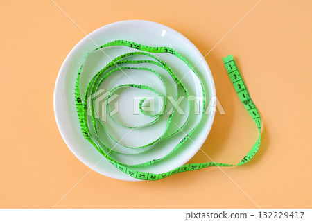 Green measuring tape on white dishwasher. Green measuring tape on white dishwasher. 132229417