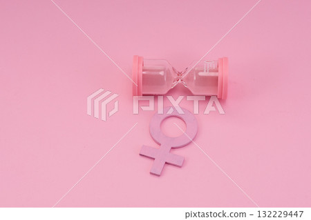 Hourglass with the female gender symbol. Women's health, menopause concept. 132229447