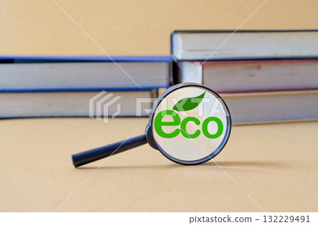 A magnifying glass with a eco text and book background. A magnifying glass with a eco text and book background. 132229491
