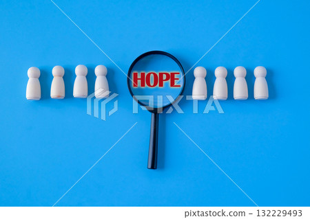 HOPE text on magnifying glass with Wooden figure standing. HOPE text on magnifying glass with Wooden figure standing. 132229493