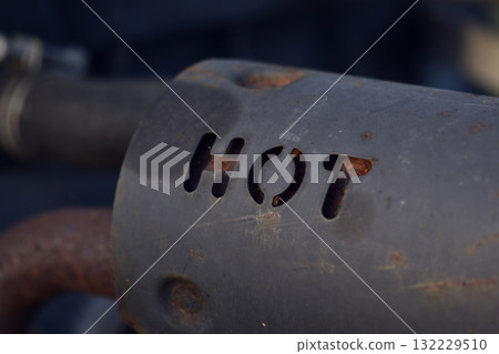 The text, the word hot, punched holes on the black steel pipe of the machine. 132229510