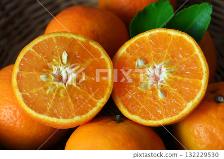 Close of sliced orange top view on pile of orange in basket 132229530