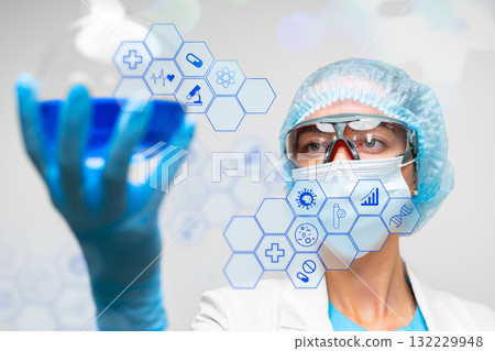 Scientist examining a blue substance during a research experiment in a laboratory setting 132229948