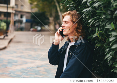 Young man talking on the phone in a quiet urban park on a sunny day 132229968