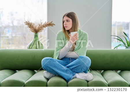 Portrait of relaxed beautiful young woman sitting at home on sofa with cup Portrait of relaxed beautiful young woman sitting at home on sofa with cup 132230170