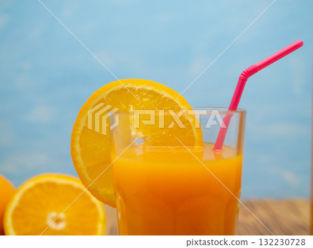 Fresh juice, mix fruits, orange drink on a blue background. Glass with orange cocktail. Fresh juice, mix fruits, orange drink on a blue background. Glass with orange cocktail. 132230728