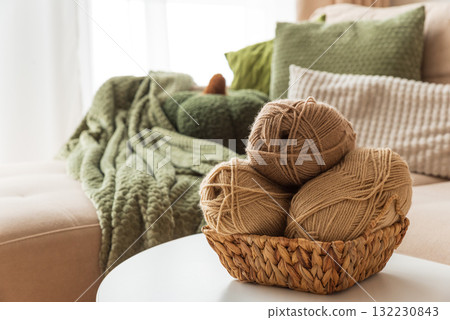 Basket with Yarn Balls on White Table in Cozy Living Room Basket with Yarn Balls on White Table in Cozy Living Room 132230843